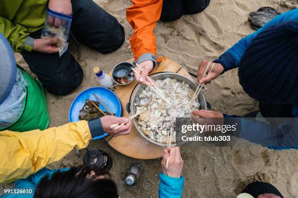 Close up of people cooking outdoors while camping