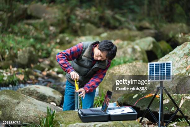 a scientist monitoring water quality from a solar powered field laboratory - pollution officer stock pictures, royalty-free photos & images