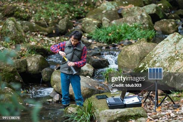 a scientist monitoring water quality from a solar powered field laboratory - pollution officer stock pictures, royalty-free photos & images