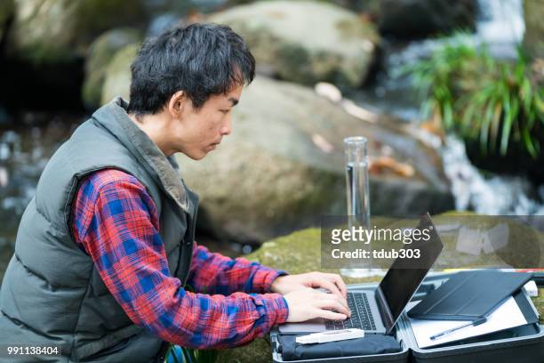 a scientist monitoring water quality from a solar powered field laboratory - pollution officer stock pictures, royalty-free photos & images