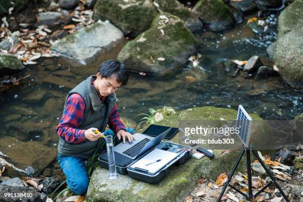 a scientist monitoring water quality from a solar powered field laboratory - forestry stock pictures, royalty-free photos & images