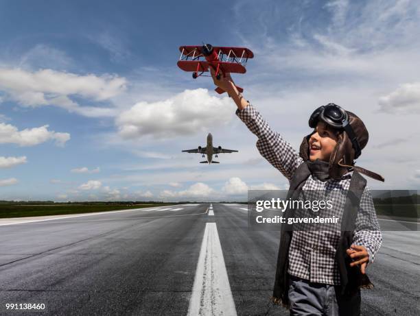 ragazzo che gioca con l'aereo giocattolo in passerella - biplano foto e immagini stock