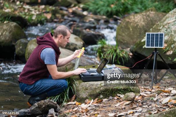 A scientist monitoring water quality from a solar powered field laboratory