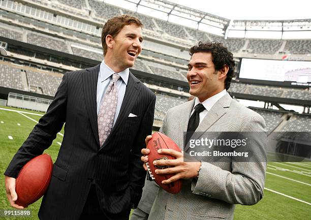 Eli Manning, quarterback of the New York Giants, left, and Mark Sanchez, quarterback of the New York Jets, pose for photographers during a news...