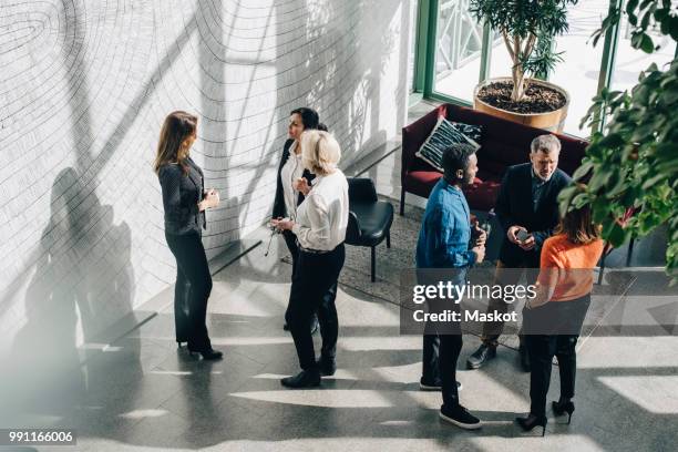 high angle view of male and female business colleagues communicating at conference - 50 sombras fotografías e imágenes de stock