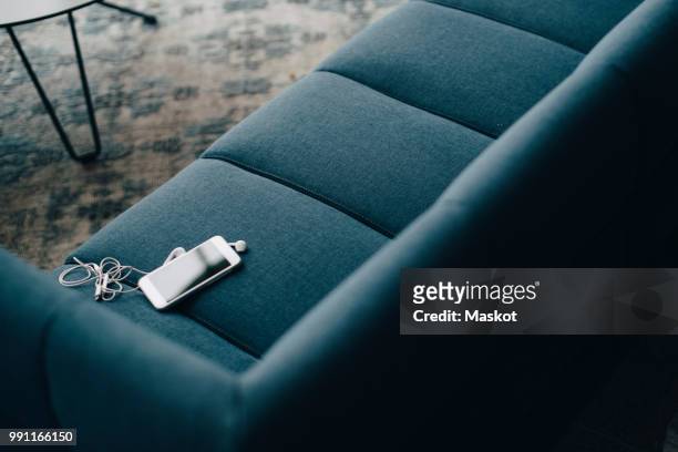 High angle view of smart phone on couch at office in conference