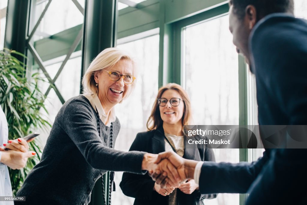 Senior businesswoman greeting colleagues during conference