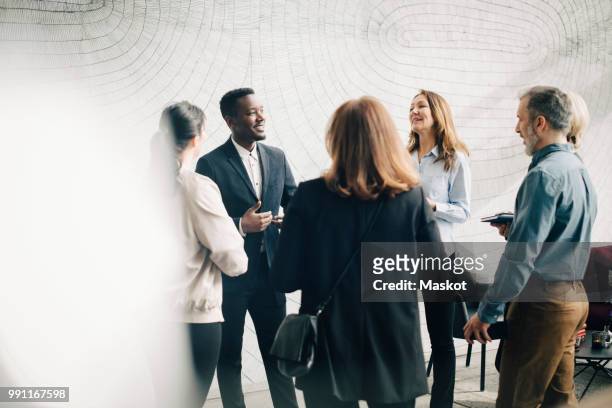male and female business colleagues discussing in meeting at office - sociale bijeenkomst stockfoto's en -beelden