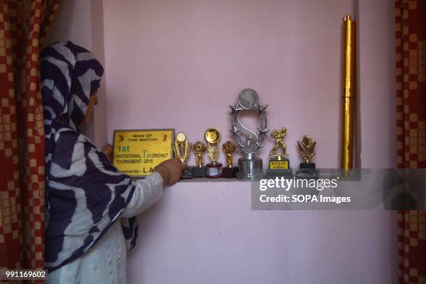 Sister to the slain militant touches the mementos of her brother. Family claiming the body of slain militant, Mudasir Ahmad Bhat, 31 who was killed...