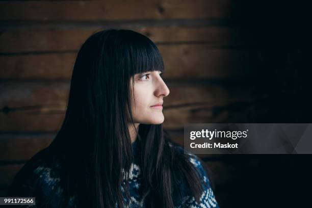 close-up of thoughtful woman looking away at log cabin - swedish log cabin bildbanksfoton och bilder