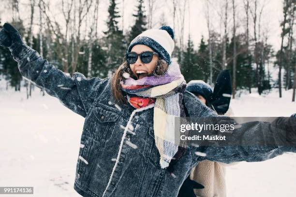 happy woman enjoying with friend at snowy field - women winter snow stock-fotos und bilder