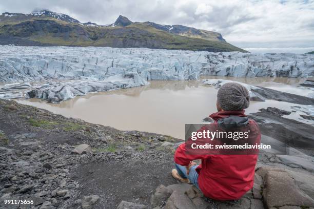 young man contemplating glacier lake in iceland - south east iceland stock pictures, royalty-free photos & images