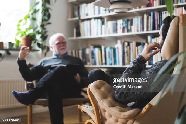 therapist explaining male patient during session at home office - mental health professional stock pictures, royalty-free photos & images