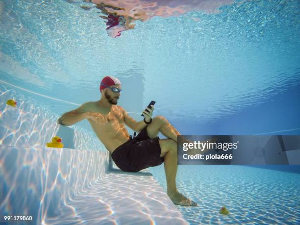 スマート フォンの活動にはまって男 - swimming underwater ストックフォトと画像