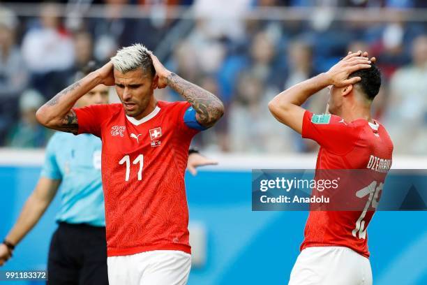 Valon Behrami and Blerim Dzemaili of Switzerland gesture during of the 2018 FIFA World Cup Russia Round of 16 match between Sweden and Switzerland at...