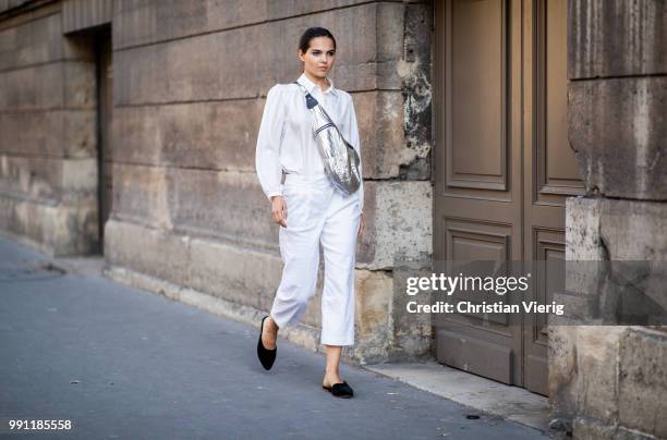 Doina Ciobanu wearing silver Isabel Marant belt bag, white pants and top is seen outside Alexandre Vauthier on day three during Paris Fashion Week...