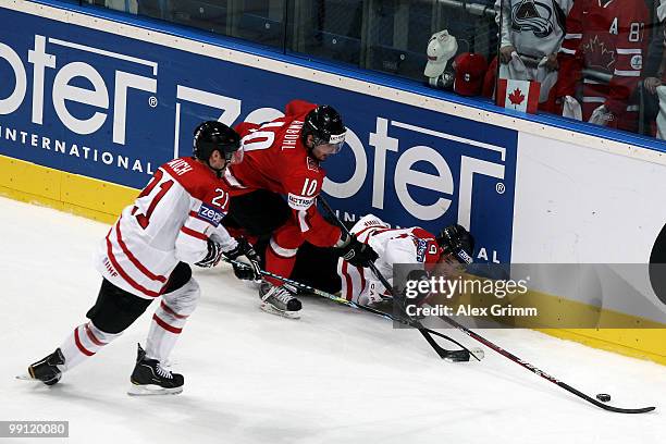 Andreas Ambuhl of Switzerland is challenged by Brooks Laich and Evander Kane of Canada during the IIHF World Championship group C match between...