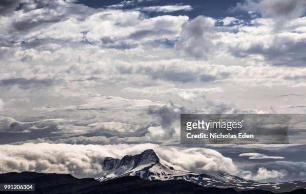 mountain engulfed by low clouds - engulfed stock pictures, royalty-free photos & images