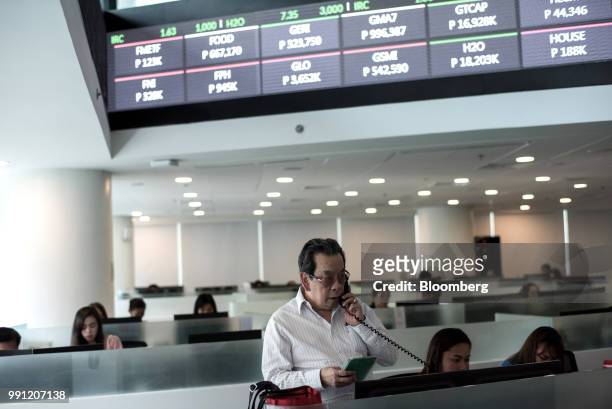 Trader speaks on the telephone while working at the trading floor of the Philippine Stock Exchange in Bonifacio Global City , Metro Manila, the...