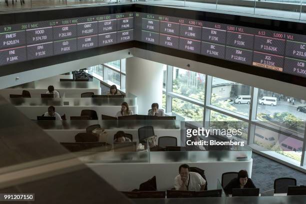 Traders work beneath an electronic ticker at the trading floor of the Philippine Stock Exchange in Bonifacio Global City , Metro Manila, the...