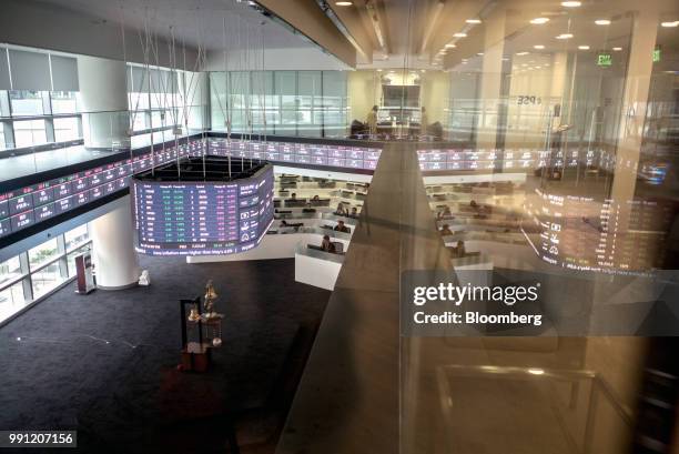 Traders work beneath a monitor and an electronic ticker at the trading floor of the Philippine Stock Exchange in Bonifacio Global City , Metro...