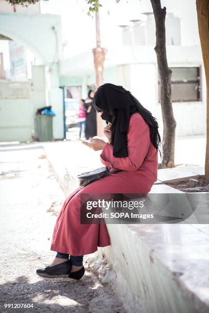 Syrian woman on her phone at a Syrian community center in Mafraq. There are about 1.4 million Syrian refugees in Jordan and only 20 percent are...