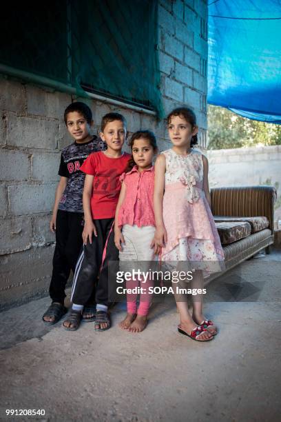 Ola and her siblings stand outside their house in Zaatari. There are about 1.4 million Syrian refugees in Jordan and only 20 percent are living in...