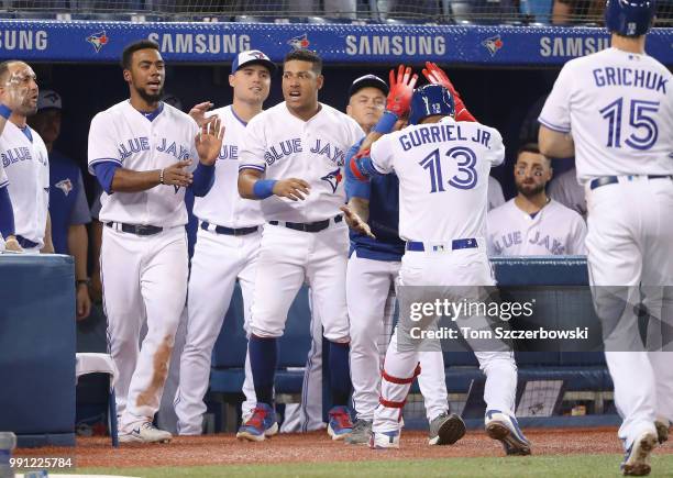 Lourdes Gurriel Jr. #13 of the Toronto Blue Jays is congratulated by Marcus Stroman after hitting a two-run home run in the eighth inning during MLB...