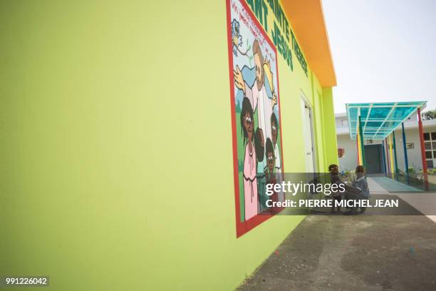 Children sit in the courtyard of 'la maison daccueil Sainte-Therese de lEnfant Jesus', a center which assists children including unaccompanied minors...