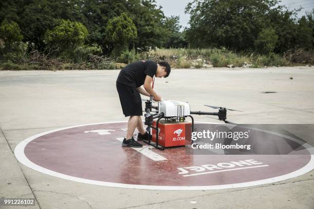 An employee prepares a JD.com Inc. Drone during a package delivery demonstration at a launch pad of the company's drone testing site in Xi'an, China,...