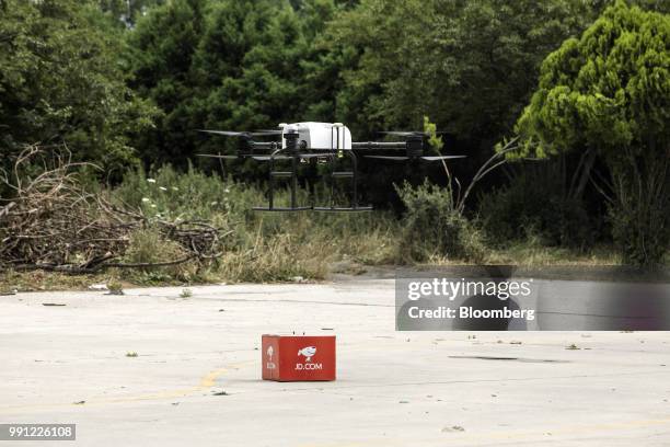 Com Inc. Drone hovers above a parcel during a package delivery demonstration at the company's drone testing site in Xi'an, China, on Tuesday, June...