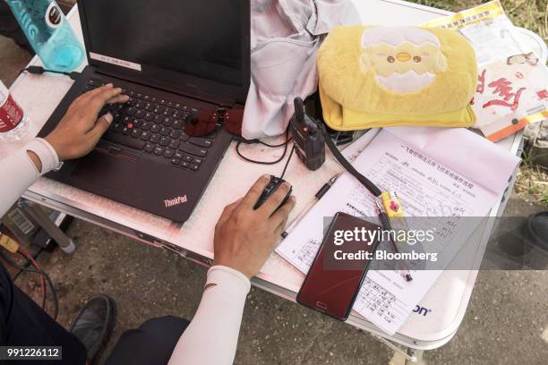 An employee plots a flight course during a JD.com Inc. Package delivery demonstration at the company's drone testing site in Xi'an, China, on...