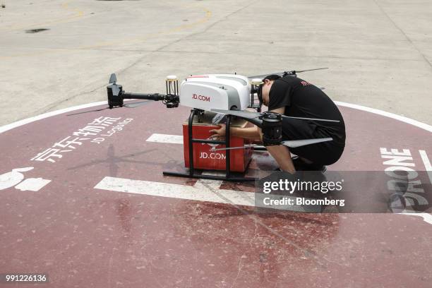 An employee prepares a JD.com Inc. Drone during a package delivery demonstration at a launch pad of the company's drone testing site in Xi'an, China,...