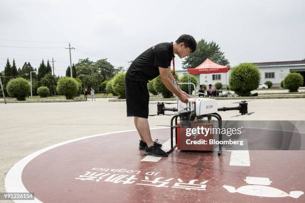 An employee prepares a JD.com Inc. Drone during a package delivery demonstration at a launch pad of the company's drone testing site in Xi'an, China,...