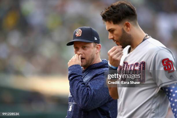 Eric Hosmer talks with manager manager Andy Green of the San Diego Padres after the umpires reversed a call and called Hosmer out at first base in...