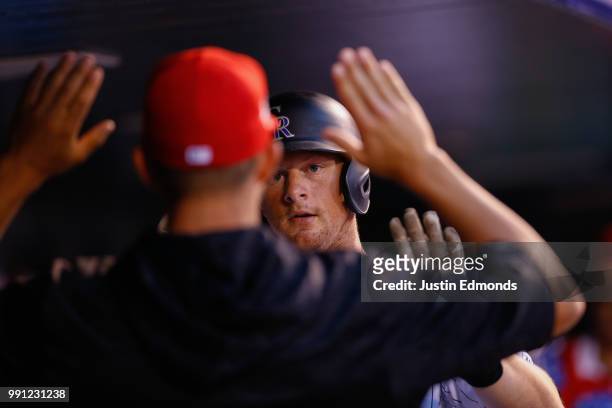 LeMahieu of the Colorado Rockies is congratulated in the dugout after scoring during the sixth inning against the San Francisco Giants at Coors Field...