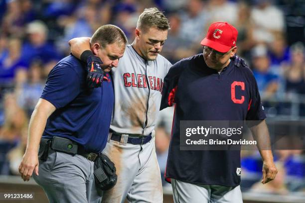 Brandon Guyer of the Cleveland Indians is helped off the field by training staff and manager Terry Francona after fouling the ball off his knee...
