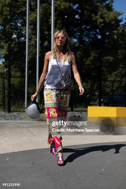 Tessa Riemeeir is seen attending Lena Hoschek wearing a silver top, elephant pattern pants while carrying her helmet during the Berlin Fashion Week...