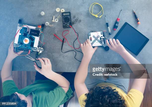 two kids builds a robot. - children in a lab stock pictures, royalty-free photos & images