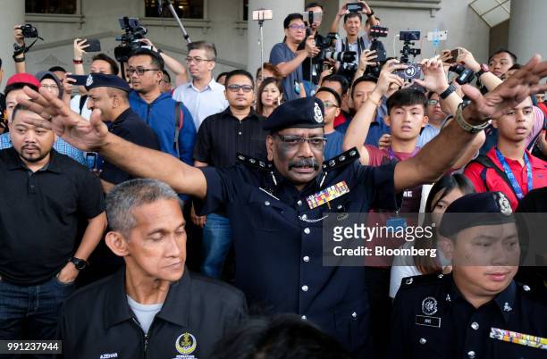 Police officer gestures to supporters of former Malaysian Prime Minister Najib Razak at the Kuala Lumpur Courts Complex in Kuala Lumpur, Malaysia, on...