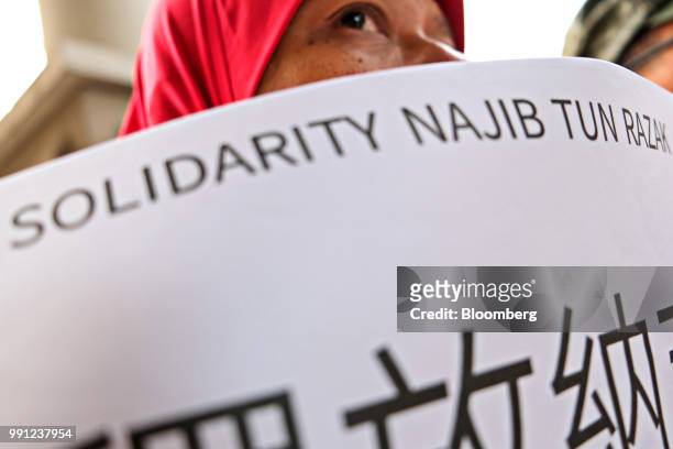 Supporter of former Malaysian Prime Minister Najib Razak holds a placard outside the Kuala Lumpur Courts Complex in Kuala Lumpur, Malaysia, on...