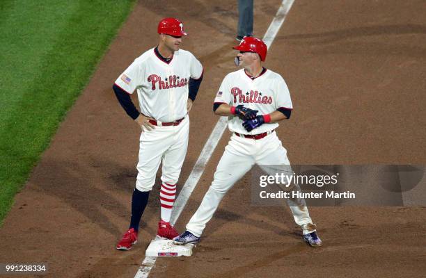 Andrew Knapp of the Philadelphia Phillies speaks with third base coach Dusty Wathan after hitting an RBI triple in the fourth inning during a game...