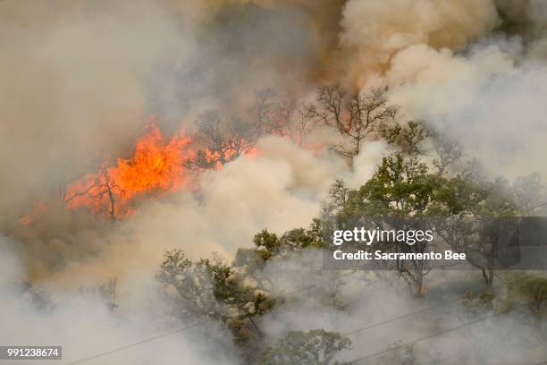 Fire consumes a hillside as the County fire burns along Highway 129 near Lake Berryessa in Yolo County, Calif., on Tuesday, July 3, 2018.