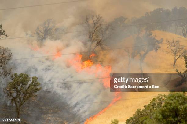 Fire consumes a hillside as the County fire burns along Highway 129 near Lake Berryessa in Yolo County, Calif., on Tuesday, July 3, 2018.