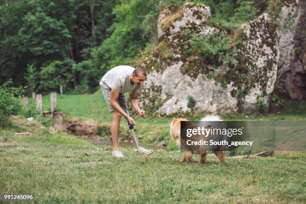 tipo de discapacidad jugando con perro chow - spitz tipo de cachorro fotografías e imágenes de stock