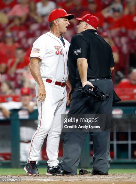 Jim Riggleman the manager of the Cincinnati Reds and umpire Eric Cooper exchange words in the 12th inning against the Chicago White Sox at Great...