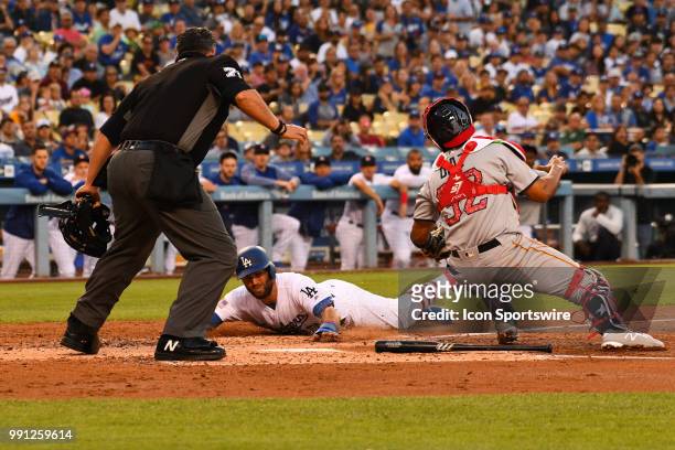 Los Angeles Dodgers infielder Chris Taylor tries to avoid the tag from Pittsburgh Pirates catcher Elias Diaz during a MLB game between the Pittsburgh...