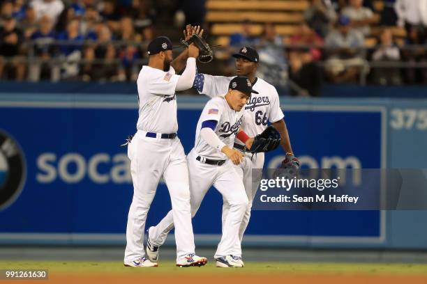 Enrique Hernandez, Yasiel Puig and Matt Kemp of the Los Angeles Dodgers celebrate defeating the Pittsburgh Pirates 8-3 in a game at Dodger Stadium on...