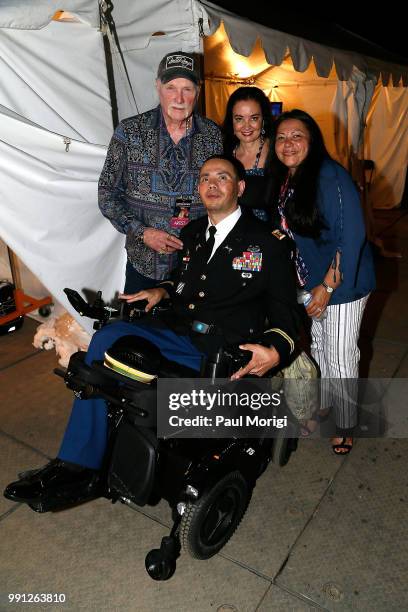 Army Capt. Luis Avila poses for a photo with Mike Love of The Beach Boys, Jacquelyne Love and Claudia Avila backstage at the 2018 A Capitol Fourth...