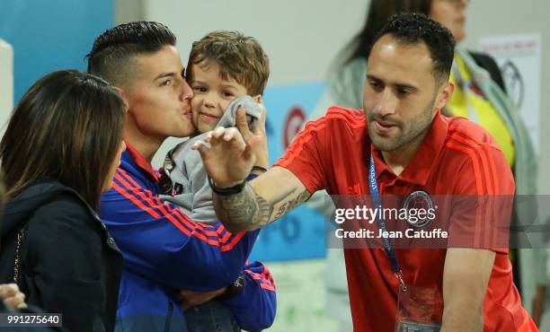 James Rodriguez of Colombia kisses Max Ospina, the son of goalkeeper David Ospina when the players join their families in the stands more than an...